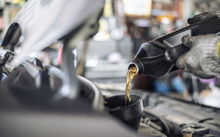 Auto Mechanic Changing Engine Oil